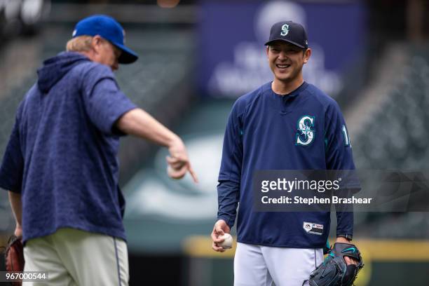 Hisashi Iwakuma of the Seattle Mariners smiles while talking with Seattle Mariners pitching coach Mel Stottlemyre before a game against the Tampa Bay...