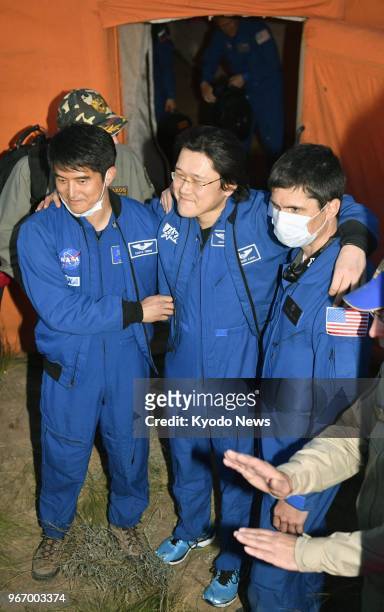Japanese astronaut Norishige Kanai stands with support of staff in Kazakhstan on June 3 after undergoing a medical checkup at a tent seen in the...