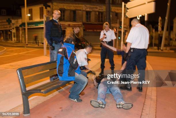 Policiers procédant à une arrestation de nuit dans une rue le 26 juin 2006 à Nanterre, France.