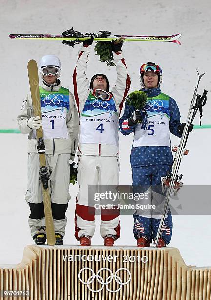 Dale Begg-Smith of Australia celebrates winning silver, Alexandre Bilodeau of Canada gold and Bryon Wilson of United States bronze during the flower...