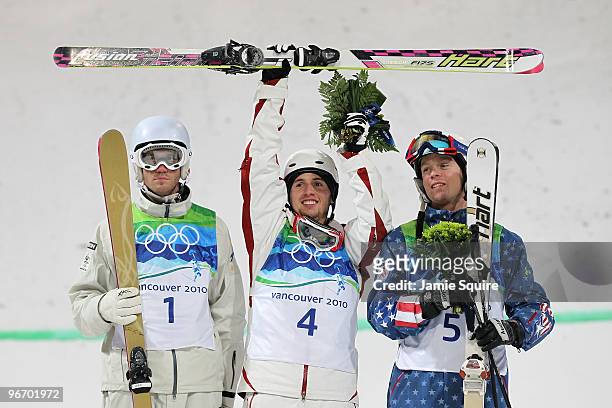Dale Begg-Smith of Australia celebrates winning silver, Alexandre Bilodeau of Canada gold and Bryon Wilson of United States bronze during the flower...