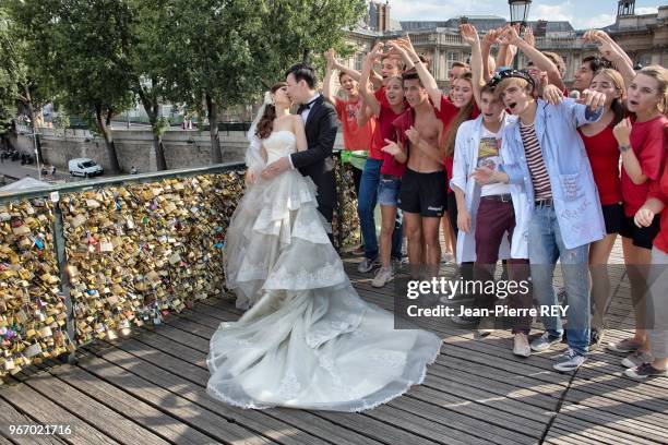 Les cadenas, que les amoureux et touristes du monde entier accrochent aux parapets du Pont des Arts vont-ils disparaitre ? Un couple de mariés...