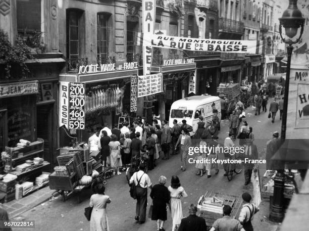 Vue très animée de la rue Montorgueil où les bouchers ont mis en application la baisse sur la viande, à Paris, France le 17 septembre 1953.