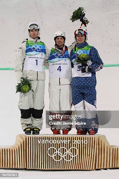 Dale Begg-Smith of Australia celebrates winning silver, Alexandre Bilodeau of Canada gold and Bryon Wilson of United States bronze during the flower...