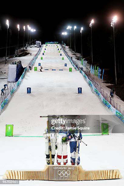 Dale Begg-Smith of Australia celebrates winning silver, Alexandre Bilodeau of Canada gold and Bryon Wilson of United States bronze during the flower...