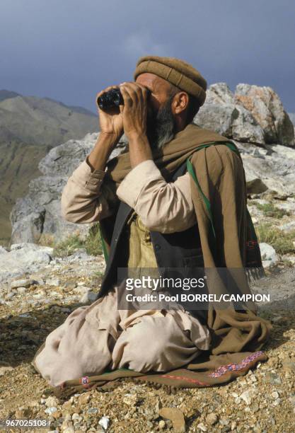 Un rebelle regardant aux jumelles lors de la guerre civile en Afghanistan le 13 juin 1984.