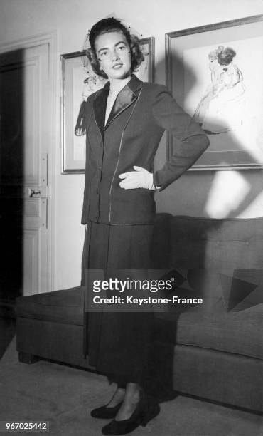 Mannequin présentant un modèle Lucile Manguin : le tailleur d'après-midi 'Rio Negro' en lainage noir avec revers et passepoil en satin noir, à Paris...