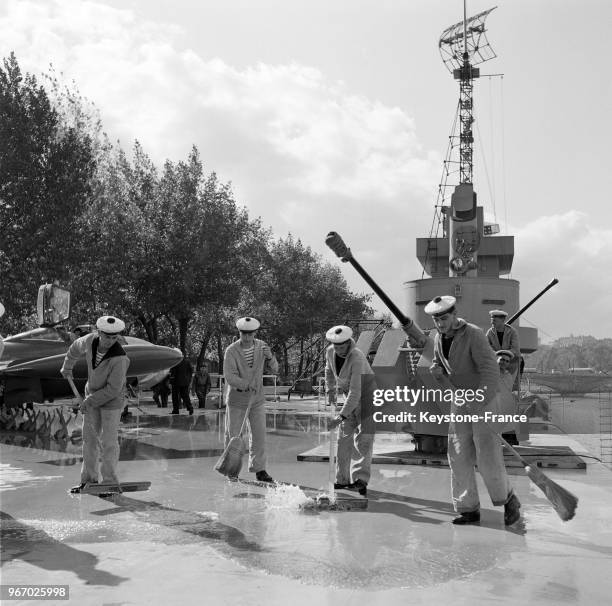 Marins nettoyant le pont du porte-avions 'Ville-de-Paris', principale attraction du salon nautique international, à Paris, France, le 30 septembre...