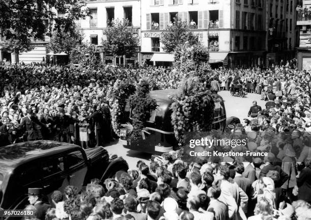 Le corbillard transportant le cercueil de Louis Jouvet passe dans les rues au milieu d'une foule immense le 21 août 1951 à Paris, France.