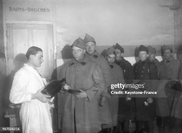 Une visite médicale dans une caserne militaire, on distribue aux soldats de l'alcool pour se gargariser, à Paris, France le 20 février 1935.