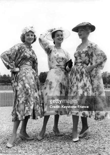 Trois jeunes femmes élégantes lors du prix des Drags à l'hippodrome d'Auteuil à Paris, France, le 22 juin 1956.