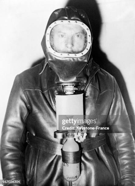 Un des tout derniers modèles d'un masque protecteur contre les gaz et la fumée porté par un pompier, à Paris, France le 28 novembre 1933.