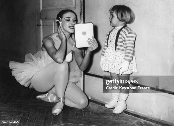 Une danseuse vérifie son maquillage dans une glace sous l'oeil intéressé d'une petite fille avant de passer l'examen d'entrée à l'Opéra-Comique le 29...