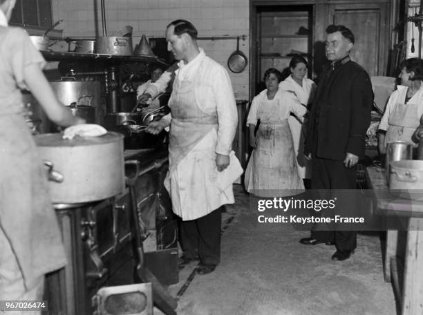 Préparation du repas de Noël pour les plus démunis dans une cuisine de l'Armée du Salut à Paris, France, le 24 décembre 1934.