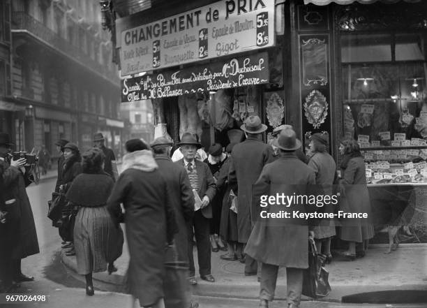 L'occasion de fêtes de Noël, dans une boucherie de la rue Saint-Georges à Paris, France, madame Duchoiseul a distribué du pot-au-feu aux personnes...