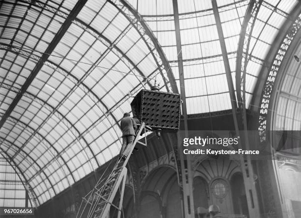 Installation des enceintes sous la verrière du Grand Palais, à Paris, France le 15 mars 1934.