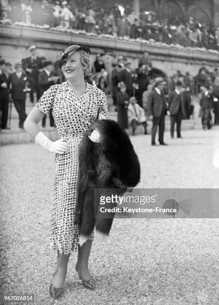 Une jeune femme vêtue d'une jolie robe aperçue aux courses de Longchamp, à Paris, France le 29 avril 1934.