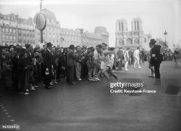 Un relais place Saint-Michel, au fond Notre-Dame, à Paris, France le 15 avril 1934.