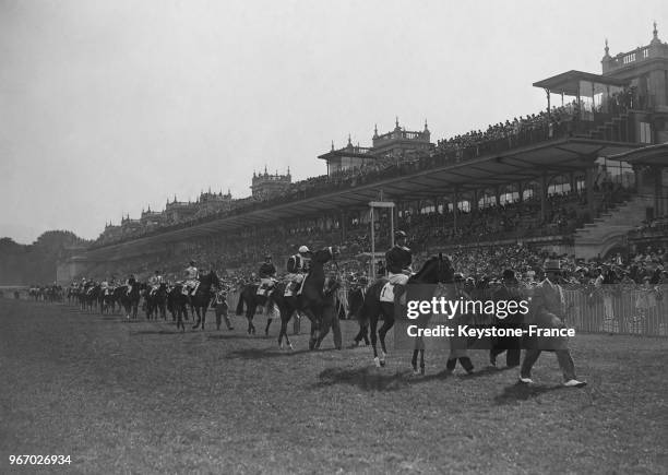 Avant la grande épreuve, les chevaux défilent devant les tribunes de l'hippodrome de Longchamp, à Paris, France le 30 juin 1935.