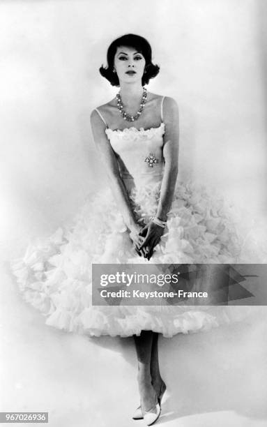 Mannequin présentant un modèle Chanel de la Collection Printemps/Eté 1959: une robe à multiples volants d'organdi de coton blanc avec un corsage...