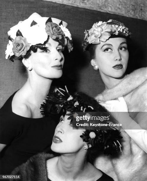 Mannequins présentant des modèles de la Collection Eté 1956: une calotte de paille d'Italie bordée de roses rouges et grises, une capeline de tulle...