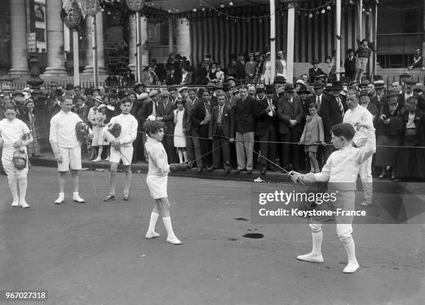 Jeune escrimeur sur la place de la Bourse à Paris, France le 14 juillet 1934.