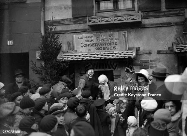 Arrivée du Père Noël sur la place du Tertre à Montmartre entouré par les enfants, à Paris, France le 24 décembre 1933.