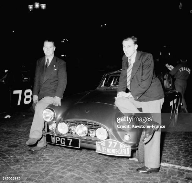 Les pilotes assis sur leur voiture de course AC au départ du Rallye Monte-Carlo au volant d'une AC, à Paris, France le 16 janvier 1956.