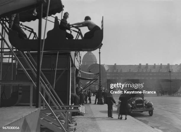 Deux hommes sur une balançoire d'un manège, à Paris, France le 28 mai 1935.