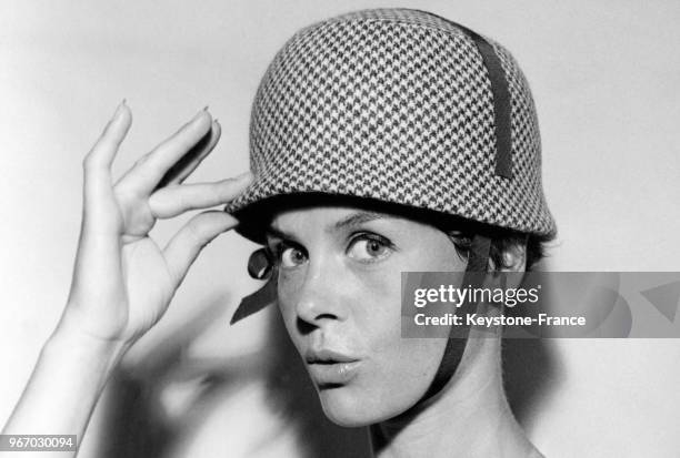 Mannequin présentant le modèle 'BB' de Jean Barthet de la Collection Automne/Hiver 1959/1960: une cloche formant un casque pied de poule bleu et...