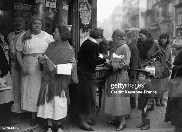 L'occasion de fêtes de Noël, dans une boucherie de la rue Saint-Georges à Paris, France, madame Duchoiseul a distribué du pot-au-feu aux personnes...