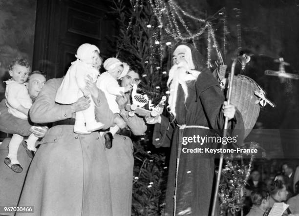 Le Père Noël distribue des jouets aux enfants des soldats du 46e régiment d'infanterie, à Paris, France le 24 décembre 1933.