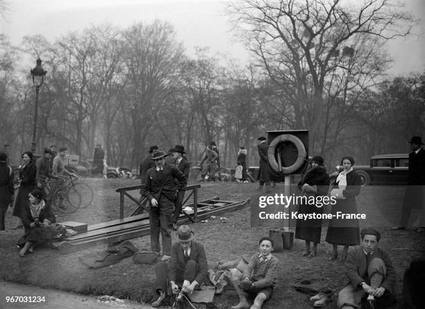 Spectateurs regardant les patineurs sur le lac gelé du Bois de Boulogne, à Paris, France le 28 janvier 1933.