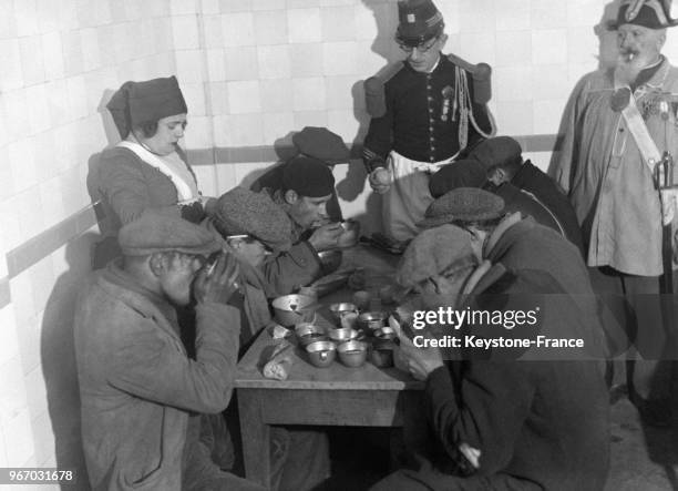 Les pauvres de Montmartre prenant un copieux dîner de Noël, à Paris, France le 26 décembre 1932.