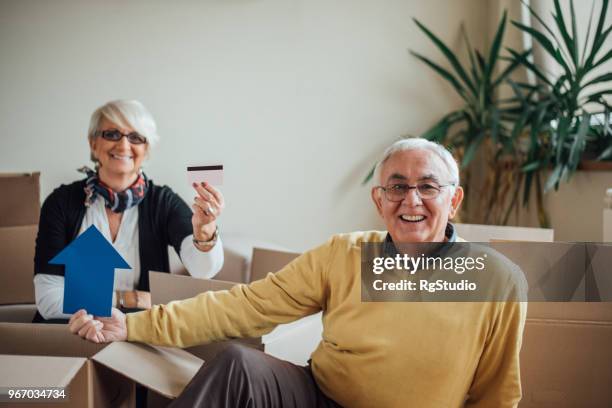 senior couple holding credit card at new apartment - letting it all hang out stock pictures, royalty-free photos & images