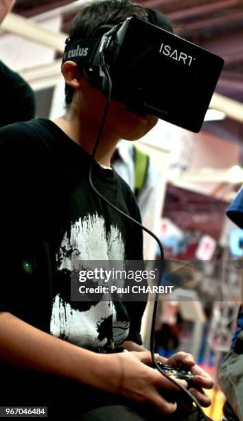 Enfant testant un jeu avec un casque de réalité virtuelle durant le 5ème salon des jeux vidéos 'Paris games Week' à Paris Expo - Porte de Versailles,...