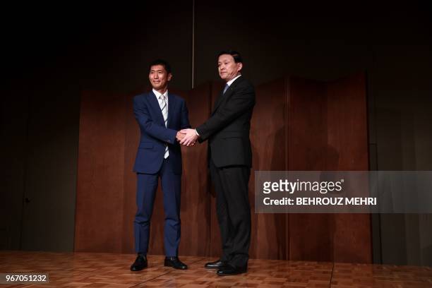 Toshiba Memory Corp. President Yasuo Naruke and head of Bain Capital's operations in Japan, Yuji Sugimoto , shake hands after a joint press...