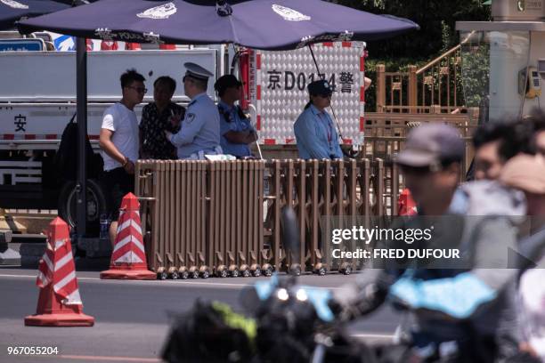 Police officers check the identity of people near Tiananmen Square on the anniversary of the 1989 crackdown on democracy protestors, in Beijing on...