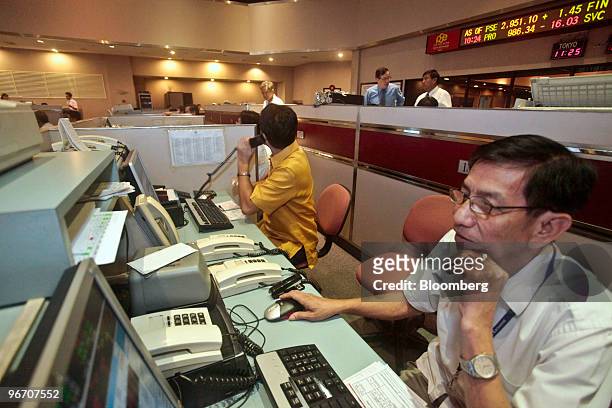 Stock brokers work on the trading floor of the Philippine Stock Exchange in Manila, the Philippines, on Monday, Feb 15, 2010. Asian stocks fell for...