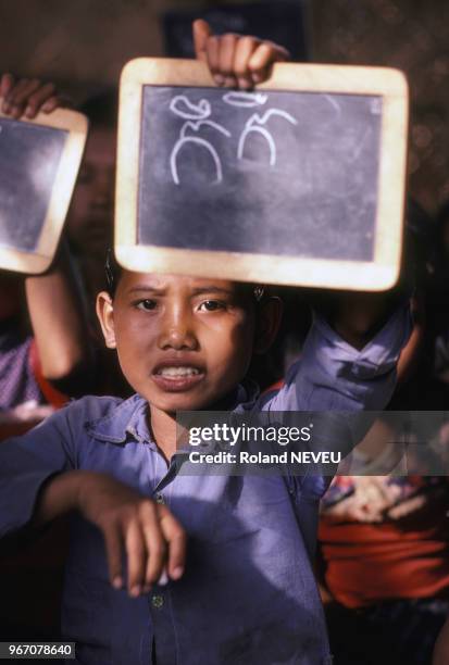 Enfant cambodgien à l'école dans un camp de réfugiés, en février 1980, France.