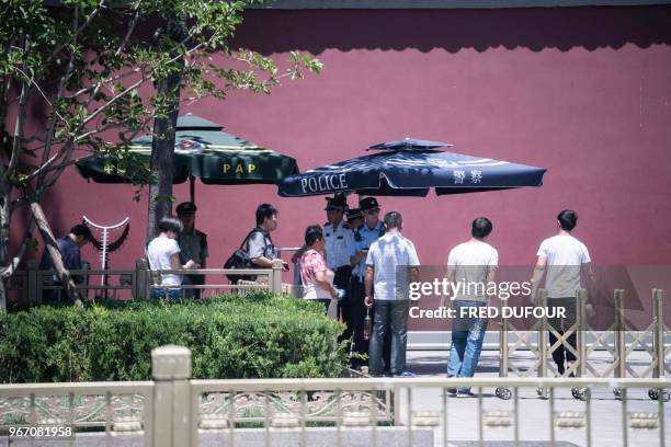 Police officers check the identity of people near Tiananmen Square, on the anniversary of the 1989 crackdown on protesters, in Beijing on June 4,...