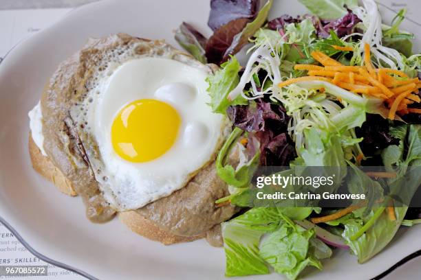 sunnyside up egg with mushroom sauce on toast served with side mesclun salad on platter. - side salad stock pictures, royalty-free photos & images