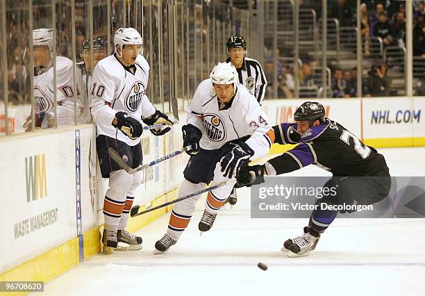 Fernando Pisani of the Edmonton Oilers skates after the puck along the right wing boards under pressure from Jarret Stoll of the Los Angeles Kings in...