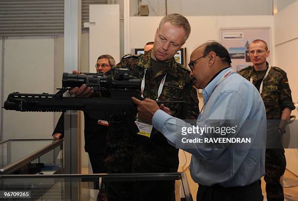 An Indian defence employee inspects a German G36 IDZ Infanterist Der Zukunft-erweitertes system during the DefExpo 2010 inauguration in New Delhi on...
