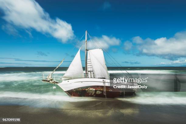 barca a vela a terra lavata sulla spiaggia - jasondoiy foto e immagini stock