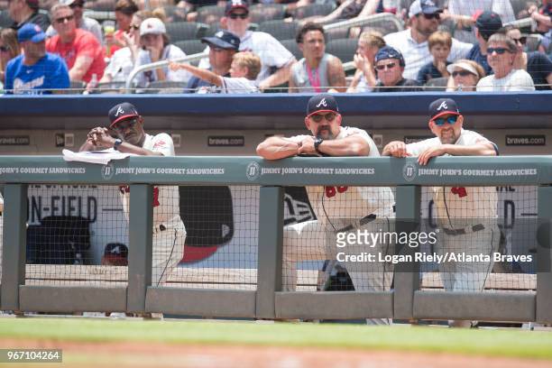 Third base coach Ron Washington, catching coach Sal Fasano and bench coach Walt Weiss of the Atlanta Braves look from the dugout against the Miami...