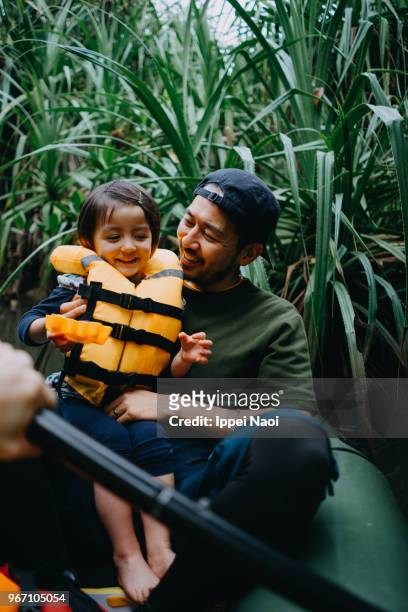 Father and child enjoying jungle river kayaking, Okinawa