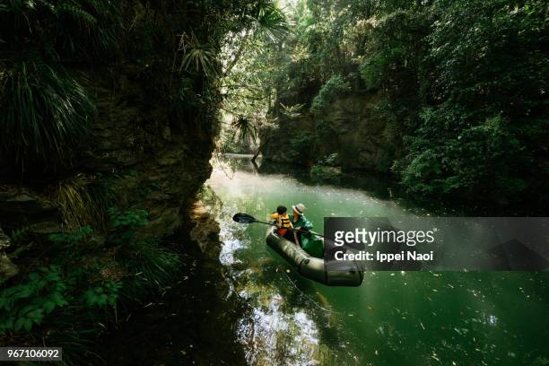 mother and child in inflatable raft on river in forest, japan - nagatoro stockfoto's en -beelden
