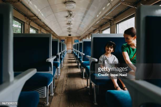 mother and child enjoying train ride - train interior stock pictures, royalty-free photos & images