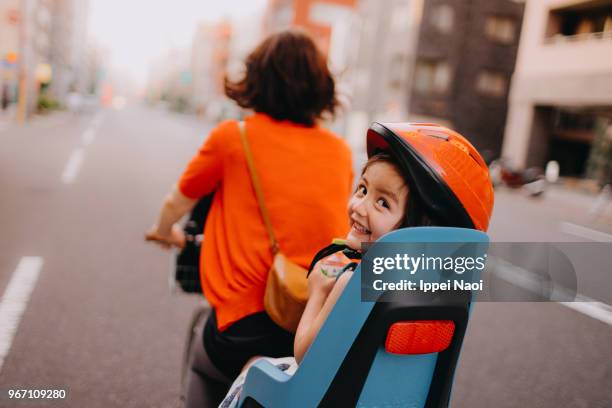 mother riding a bicycle with a toddler girl in central tokyo - commuter cycling stock pictures, royalty-free photos & images